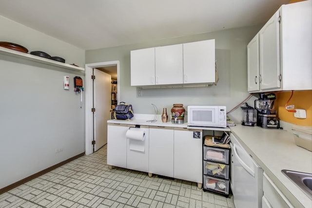 kitchen featuring light countertops, white appliances, white cabinetry, and baseboards