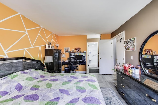 bedroom featuring wood finished floors and ensuite bathroom