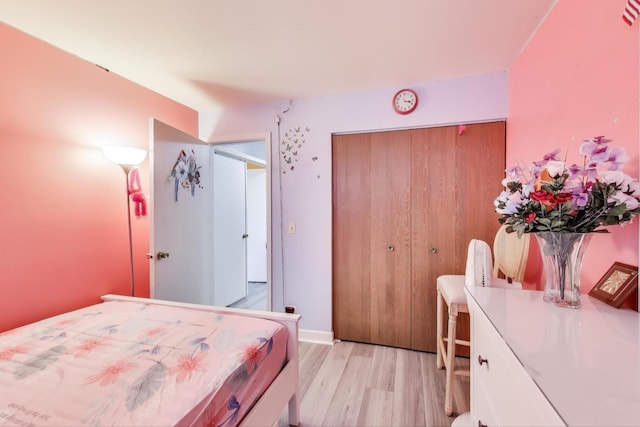 bedroom with light wood-style floors and a closet