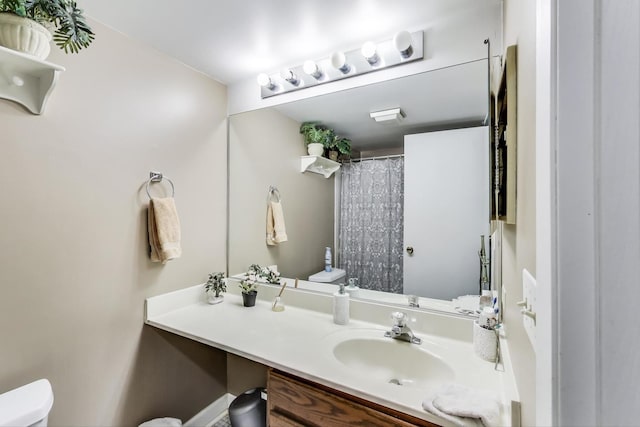 bathroom with toilet, curtained shower, and vanity