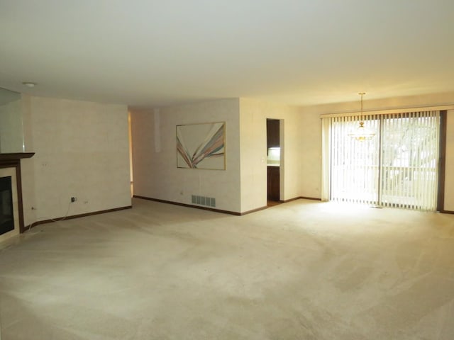 unfurnished living room with light carpet, baseboards, visible vents, and a glass covered fireplace