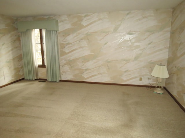 carpeted empty room with baseboards and visible vents