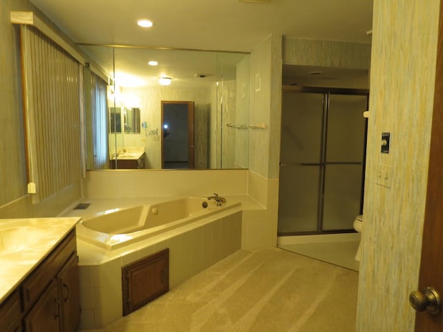 bathroom with toilet, recessed lighting, vanity, a bath, and a stall shower