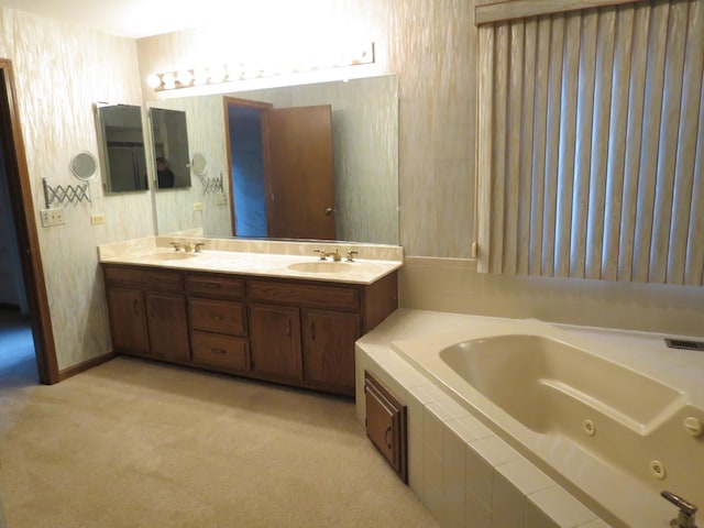 full bath featuring a jetted tub, wallpapered walls, double vanity, and a sink