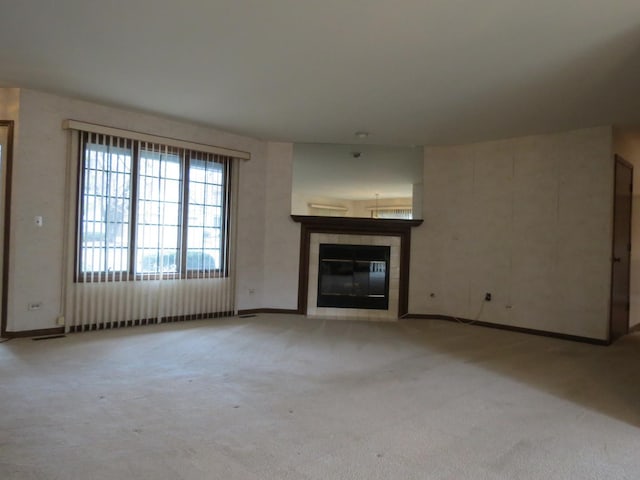 unfurnished living room featuring carpet floors and a tile fireplace