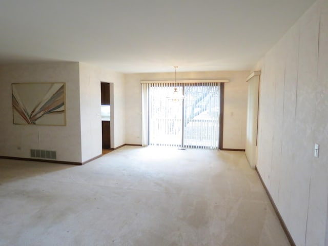 spare room featuring baseboards, visible vents, and light colored carpet