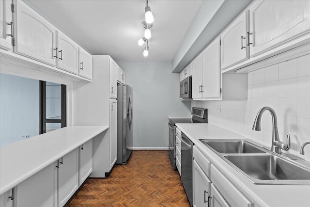 kitchen featuring tasteful backsplash, white cabinetry, stainless steel appliances, and a sink