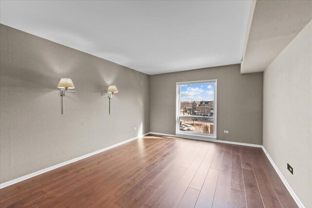 empty room with wood finished floors and baseboards