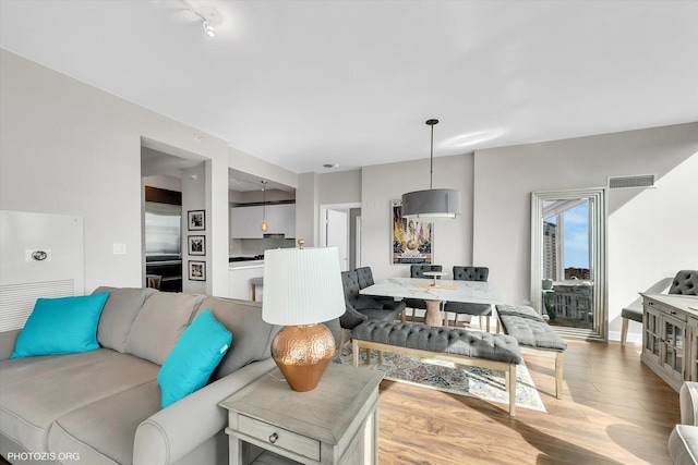 living room with visible vents and wood finished floors