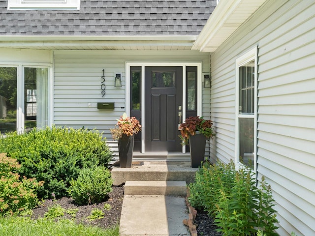 property entrance featuring roof with shingles