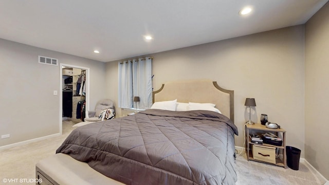 bedroom with a walk in closet, visible vents, baseboards, and recessed lighting