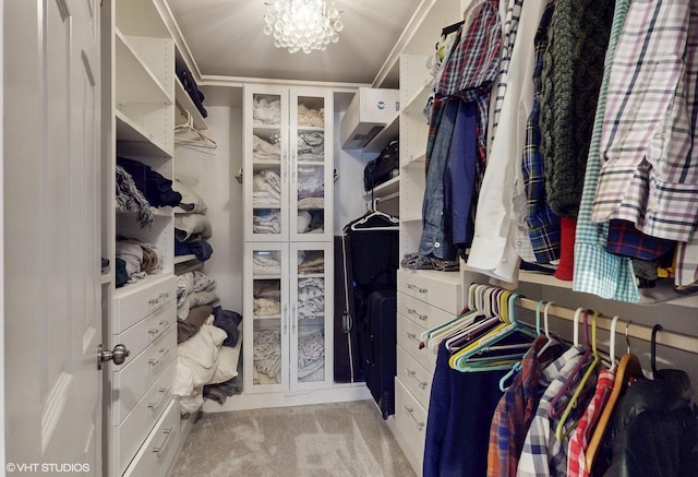 spacious closet with carpet and a chandelier