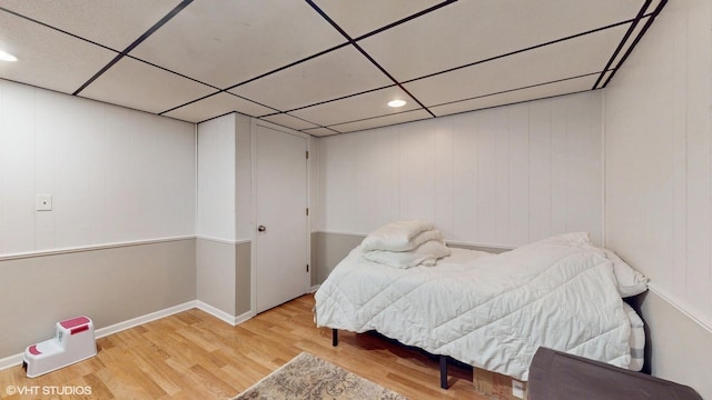 bedroom with wood finished floors, a paneled ceiling, and recessed lighting