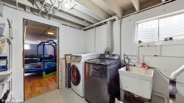 clothes washing area featuring a sink, laundry area, and washing machine and dryer