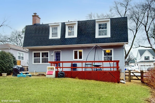 rear view of house featuring a yard, a chimney, a shingled roof, fence, and a deck