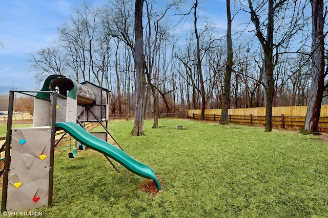 view of jungle gym featuring a lawn and fence