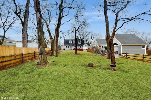 view of yard featuring a fenced backyard and a playground