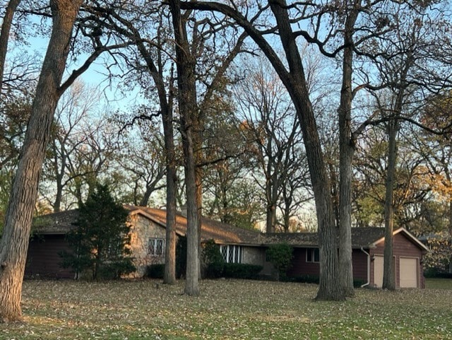 view of front of house with an attached garage and a front lawn