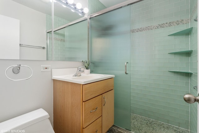 full bathroom with toilet, a shower stall, speckled floor, and vanity