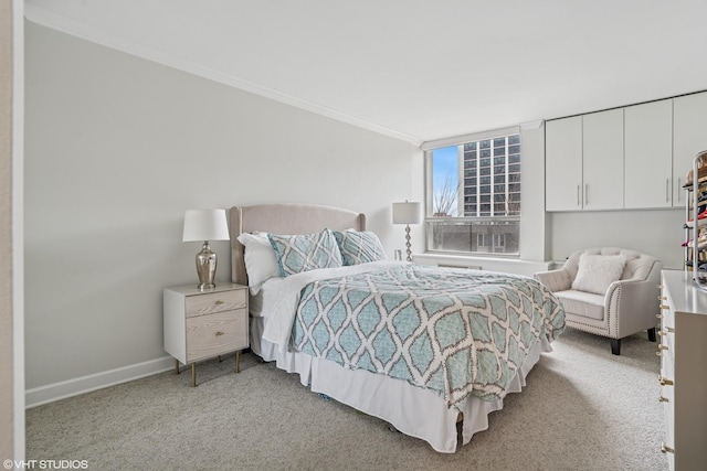 bedroom with baseboards, crown molding, and light colored carpet