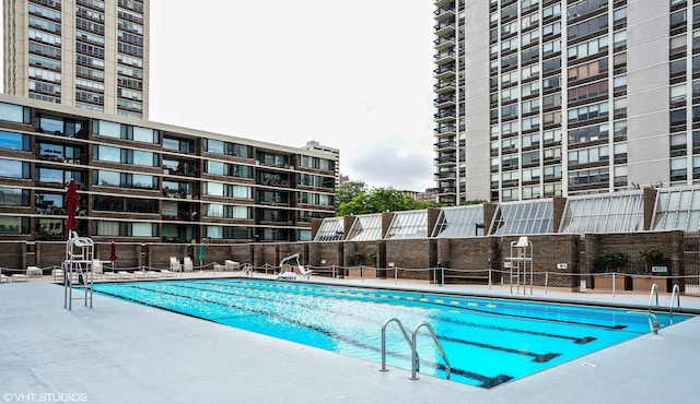 view of swimming pool featuring fence