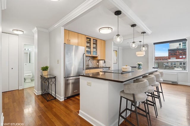 kitchen featuring ornamental molding, freestanding refrigerator, dark countertops, and black electric stovetop