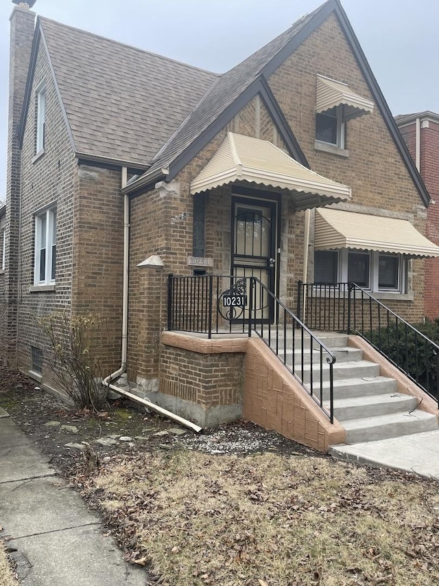 bungalow with brick siding and a chimney