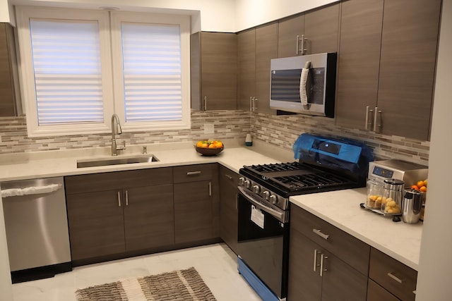 kitchen featuring stainless steel appliances, light countertops, a sink, and dark brown cabinets