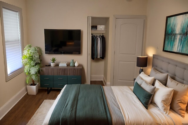 bedroom with baseboards, dark wood finished floors, and a closet