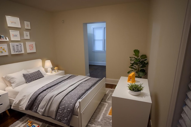 bedroom with baseboards and dark wood-type flooring