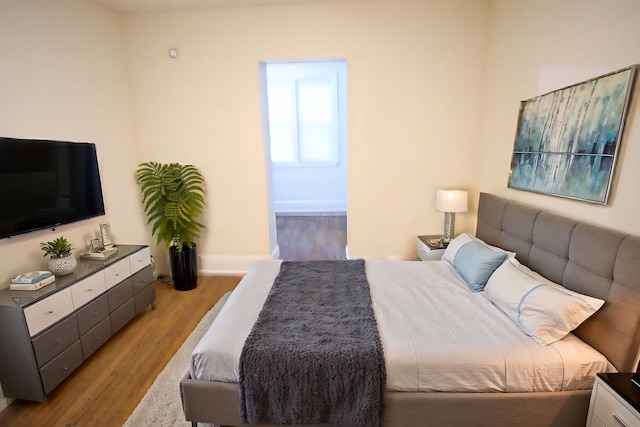 bedroom featuring baseboards and wood finished floors