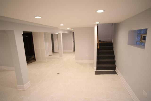 finished below grade area with recessed lighting, baseboards, and stairs