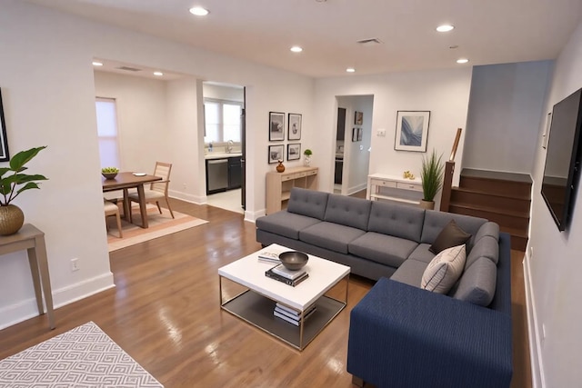 living room with baseboards, wood finished floors, visible vents, and recessed lighting