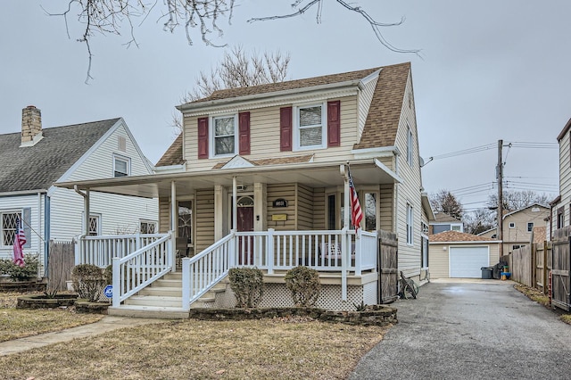 view of front of property featuring aphalt driveway, roof with shingles, covered porch, a garage, and an outdoor structure