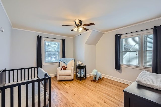 bedroom featuring a ceiling fan, light wood-style flooring, ornamental molding, and baseboards