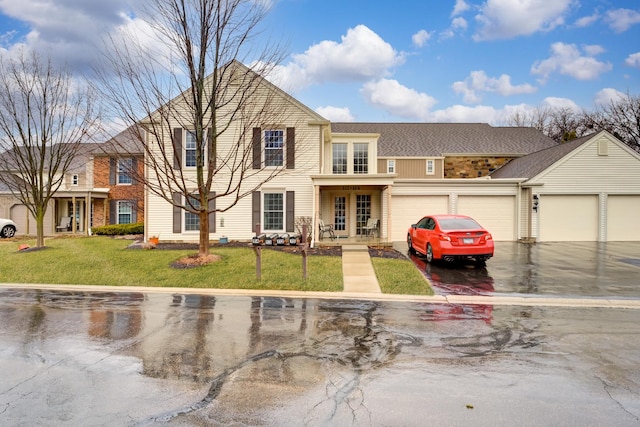 view of front of property featuring a garage, aphalt driveway, and a front lawn