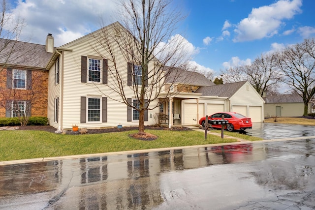 view of front of home featuring a garage, driveway, and a front yard