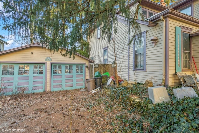 view of property exterior featuring a detached garage and an outbuilding