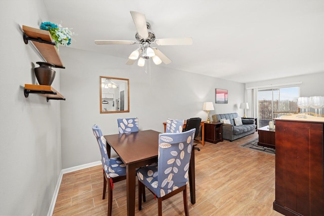 dining area featuring light wood-style floors, baseboards, and a ceiling fan