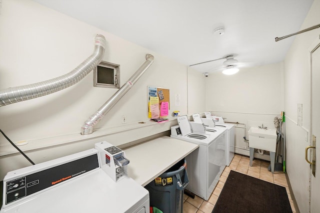 community laundry room with ceiling fan, washing machine and dryer, a sink, and light tile patterned floors