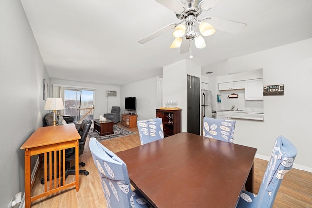 dining room featuring light wood finished floors, ceiling fan, and baseboards