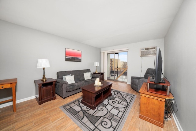 living area with a wall unit AC, light wood-style flooring, and baseboards