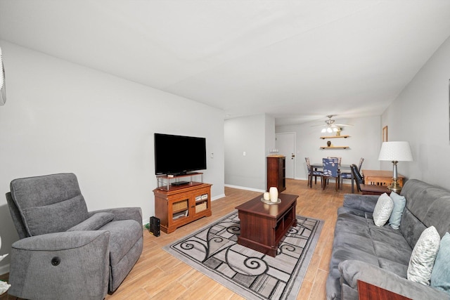 living area with ceiling fan, light wood finished floors, and baseboards