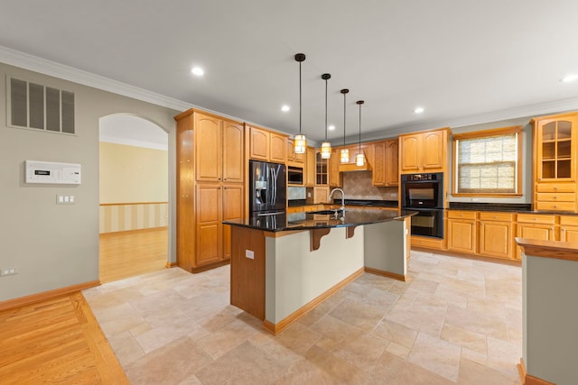 2811 Haven Ct, Naperville, IL 60564 - kitchen with a breakfast bar, glass insert cabinets, a kitchen island with sink, visible vents, and black appliances