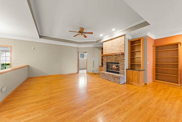 2811 Haven Ct, Naperville, IL 60564 - unfurnished living room with light wood-style flooring, crown molding, a fireplace, a ceiling fan, and a tray ceiling