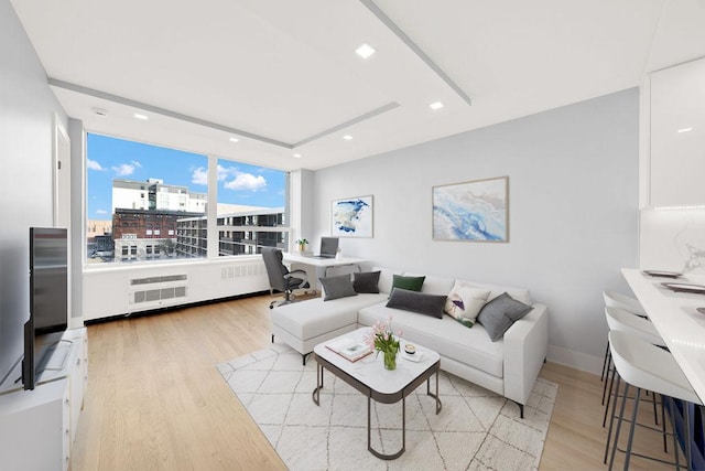 living area with baseboards, a city view, wood finished floors, and recessed lighting