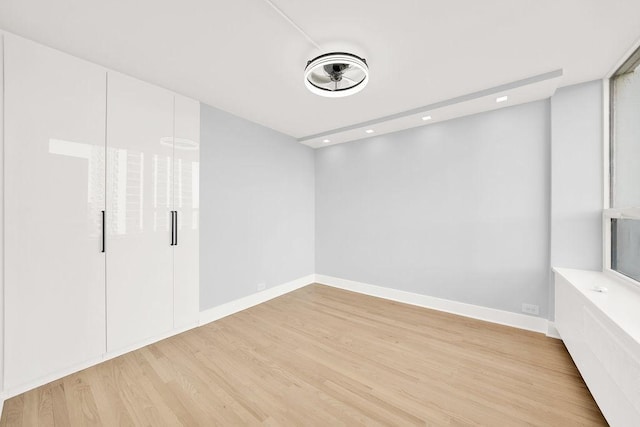 unfurnished bedroom featuring light wood-type flooring, baseboards, and recessed lighting