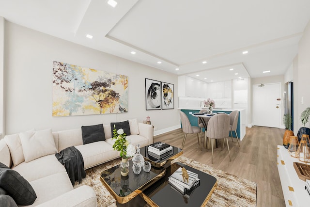 living room featuring baseboards, recessed lighting, and light wood-style floors