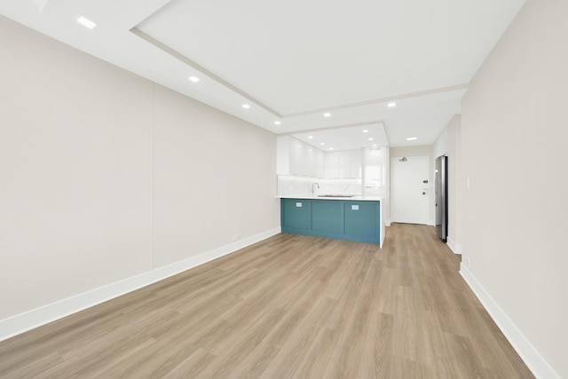 unfurnished living room featuring light wood-type flooring, baseboards, and recessed lighting