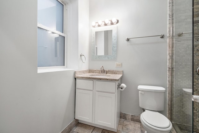 full bathroom featuring a tile shower, vanity, toilet, and baseboards